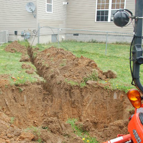 Dry well or drainfield excavation leading to a residential home