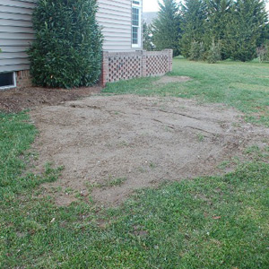 Excavation site for dry well next to a home