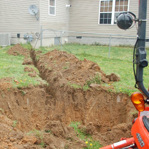 Experts installing a dry well and drainage system from a residential home